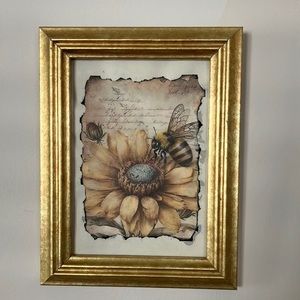 Gold framed print of bee/flower.